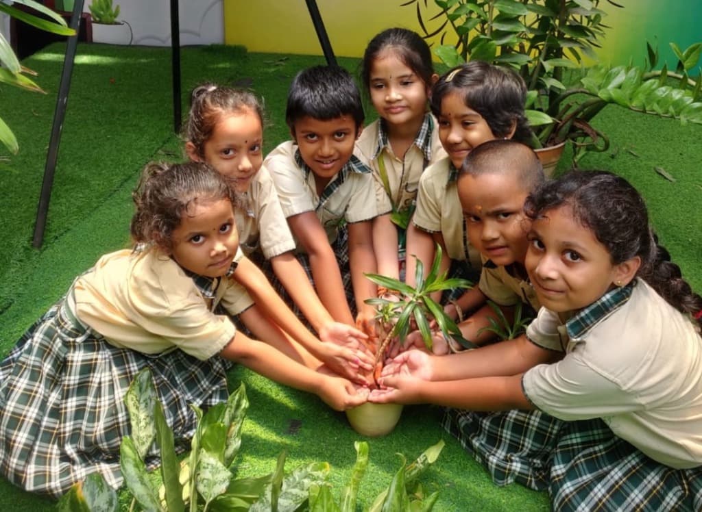 Children planting sapling outdoors