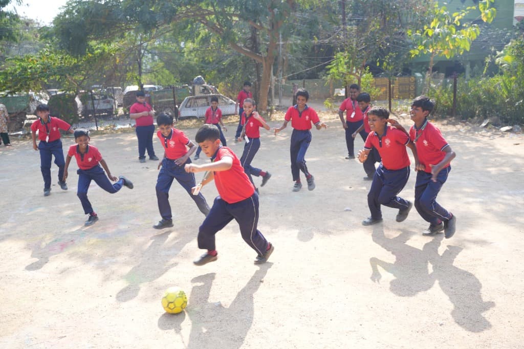 Children playing football outdoors — inspired young learners
